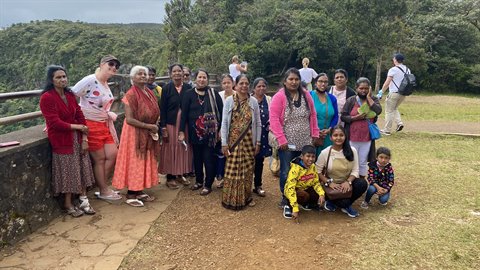 Group of tourists posing on a viewpoint terrace, soft light, traditional clothes