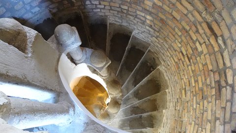 Spiral brick staircase seen from above inside a stone tower