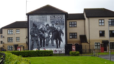 Civil rights mural painted on the gable wall of residential houses under grey sky