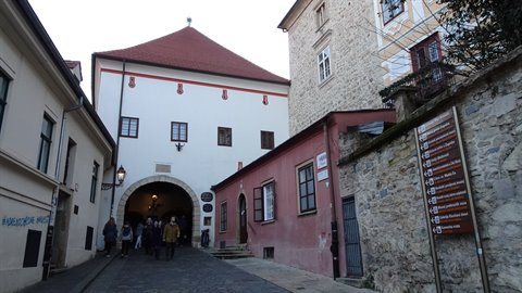 Visitors passing under Zagreb's Stone Gate among old stone buildings