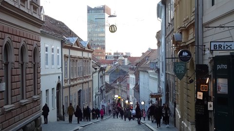 Pedestrians on Radiceva street in Zagreb among historic buildings and modern tower