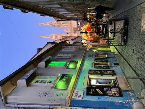 Cobbled Zagreb street with colorful facades and the illuminated cathedral in the background