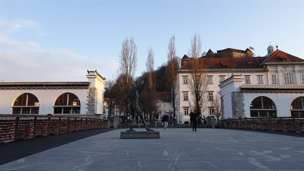 Bronze statue on the Butchers' Bridge in Ljubljana, castle on the hill