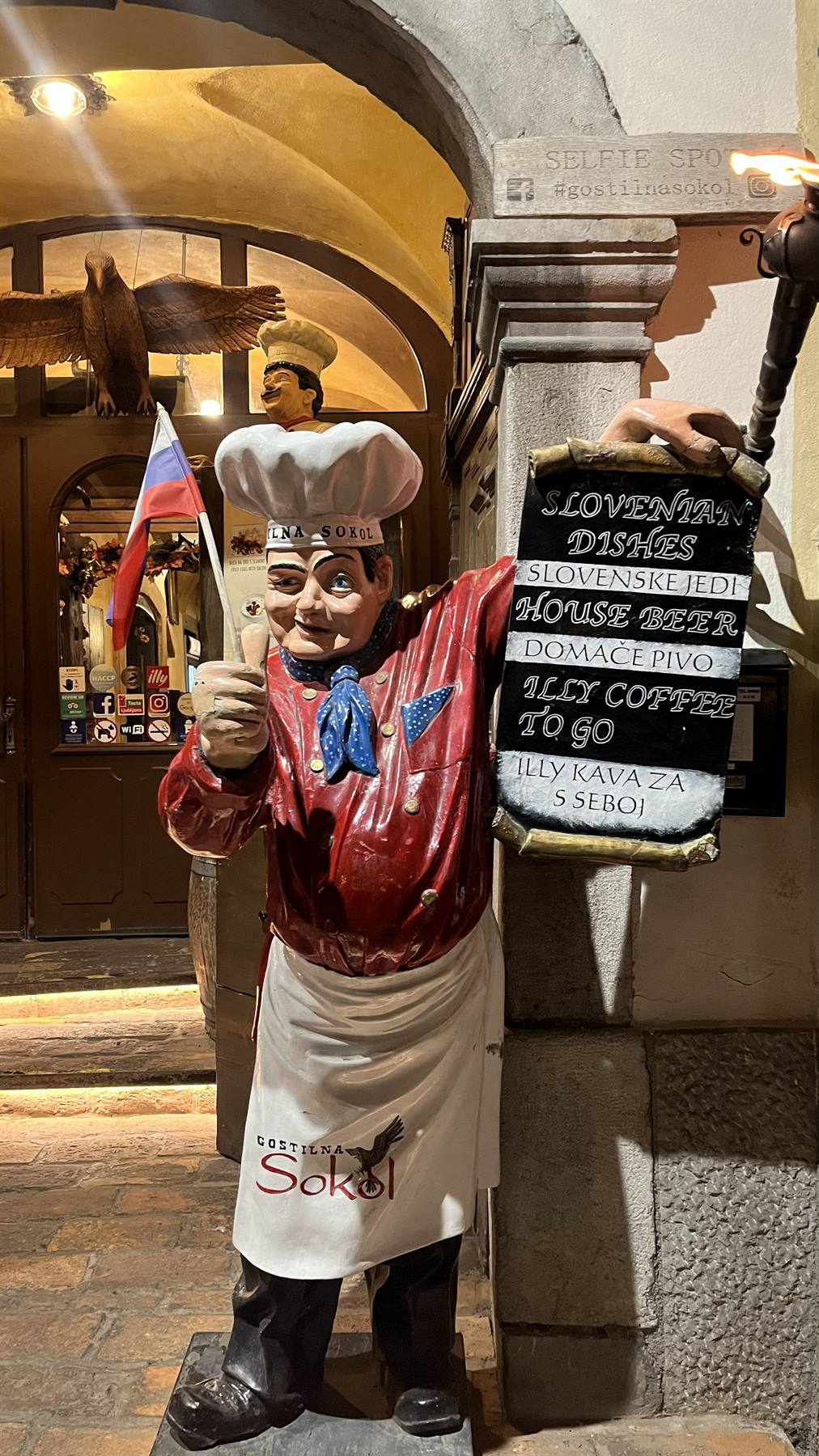 Statua di cuoco con bandiera slovena davanti alla Gostilna Sokol a Lubiana