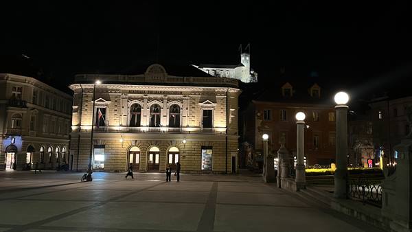 Prešeren Square in Ljubljana at night, illuminated building and dark sky