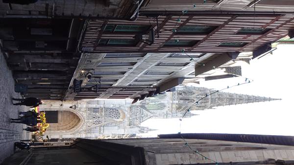Timbered houses and gothic spire of Rouen Cathedral above narrow street