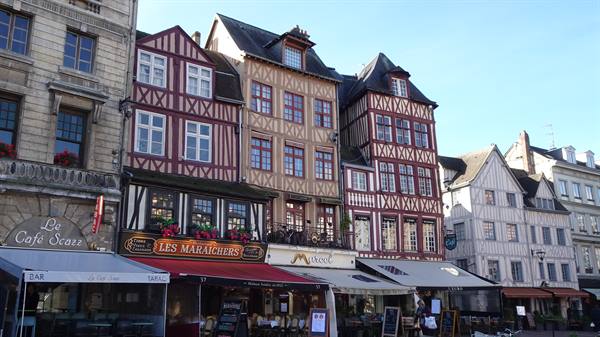 Red half-timbered houses and café awnings on a square in Rouen
