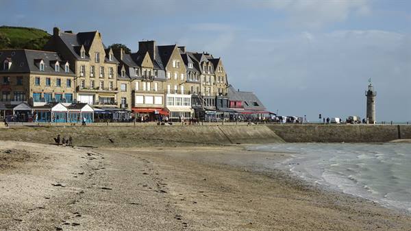Stone houses along Cancale seafront, lighthouse at low tide