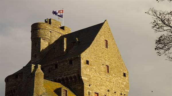 Massive granite keep with a flag blowing in the wind, Saint-Malo castle
