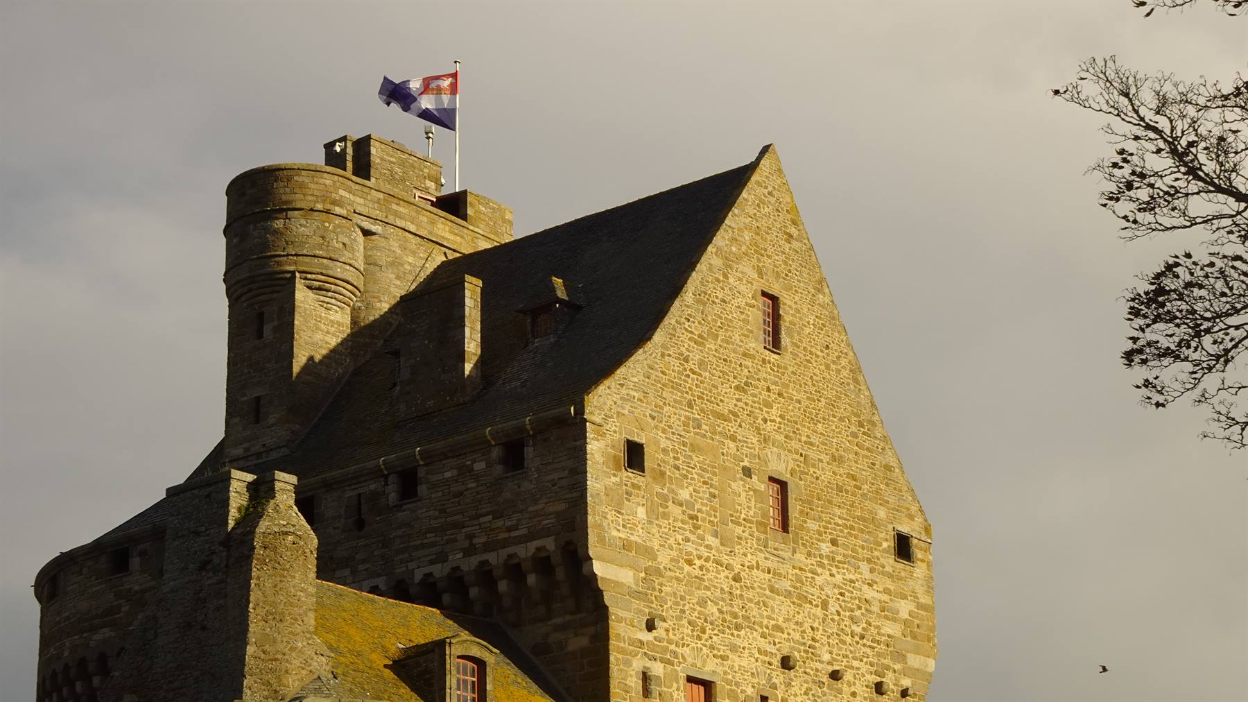 Massiccio torrione in granito con bandiera al vento, castello di Saint-Malo