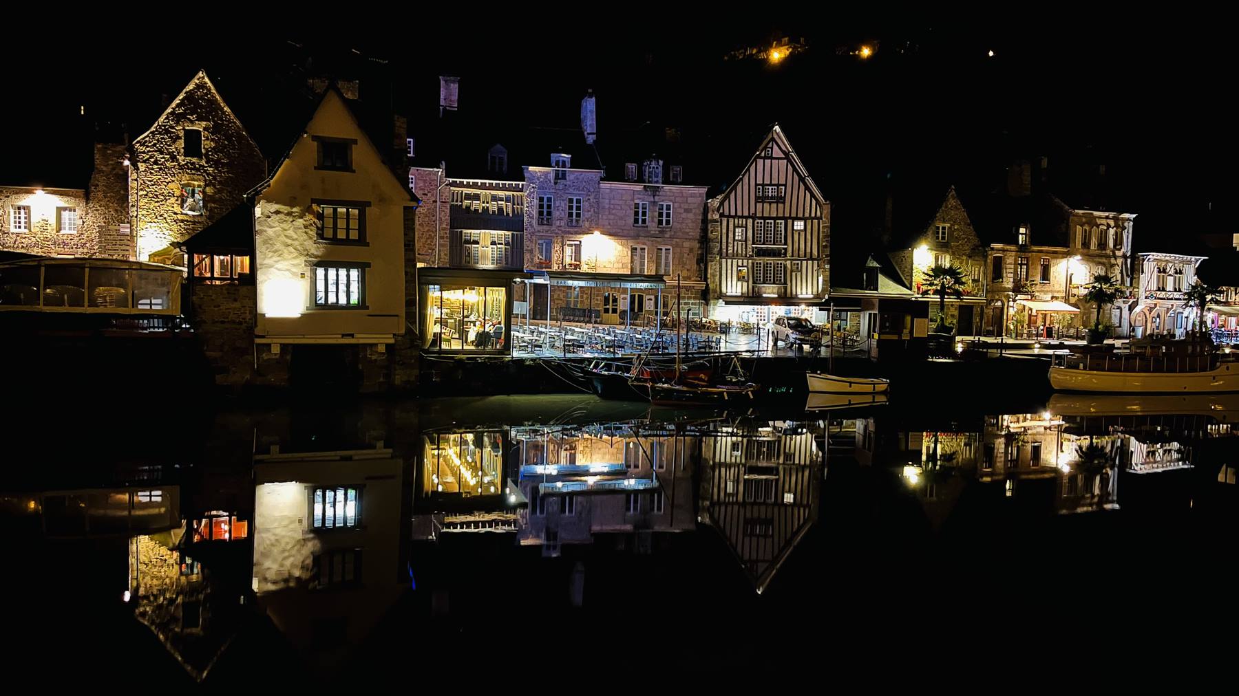 Case a graticcio illuminate di notte riflessse nell'acqua del porto di Auray