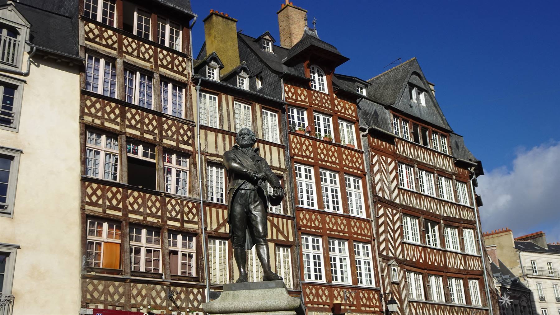 Statua in bronzo davanti alle case a graticcio di Rennes, Place du Champ-Jacquet