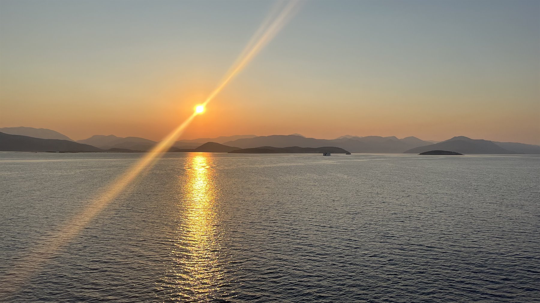 Tramonto dorato sul mare: il viaggio ci regala un momento perfetto.