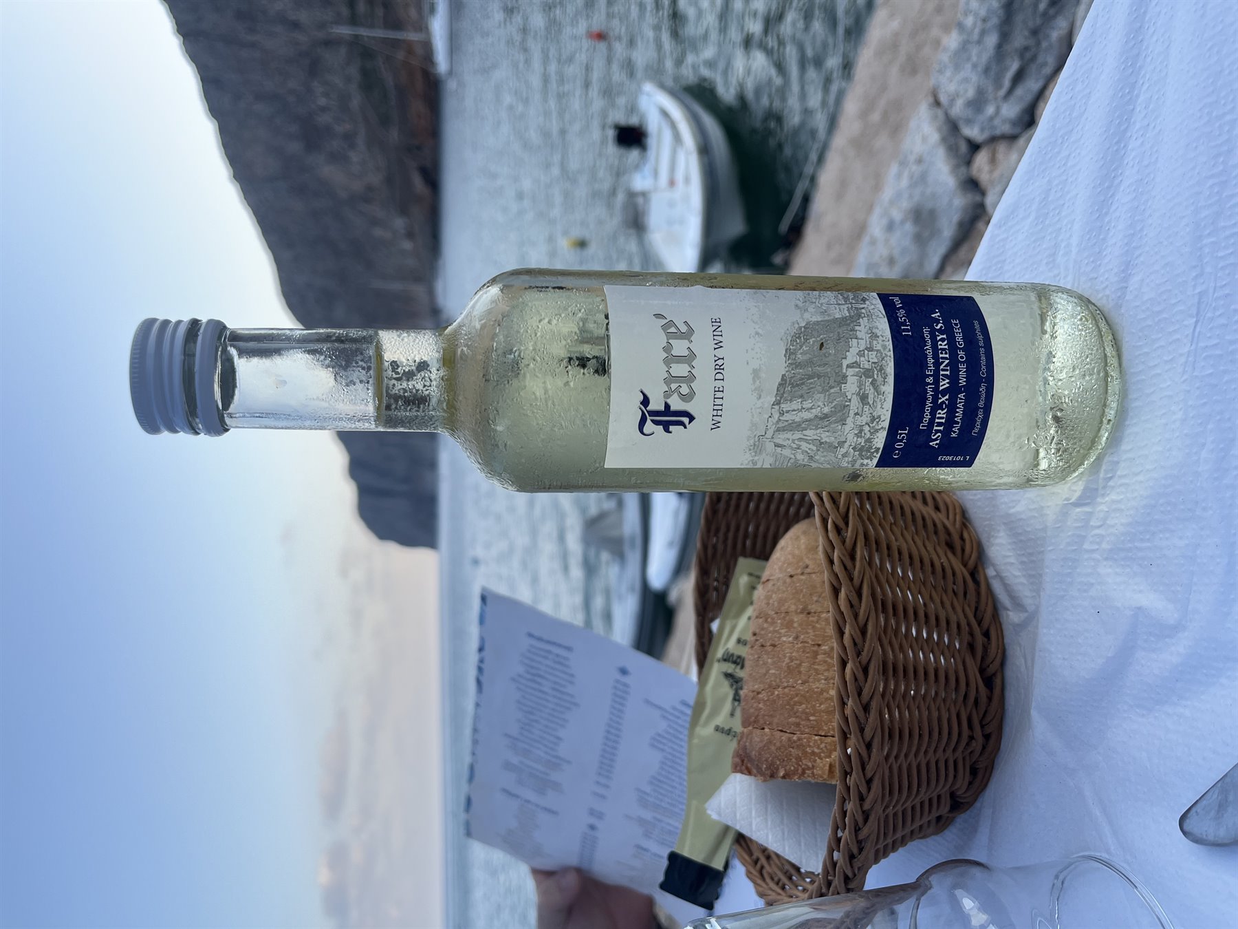 Vino bianco fresco, pane e mare: il tramonto sa di vacanza.