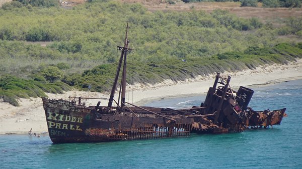 The old shipwreck sleeps in turquoise waters, a moving encounter.