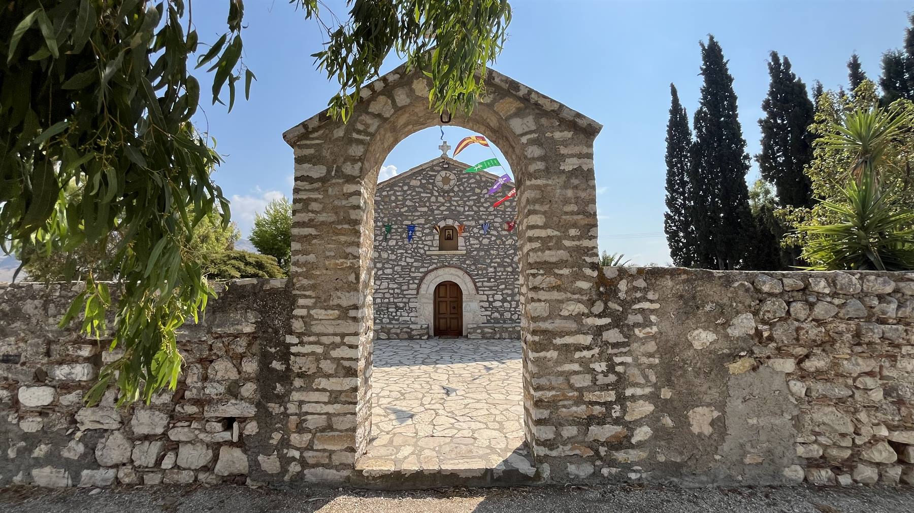 Attraverso l'arco di pietra, una piccola chiesa custodisce silenzi e meraviglie.