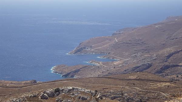The endless blue of the sea meets the golden hills of the island.