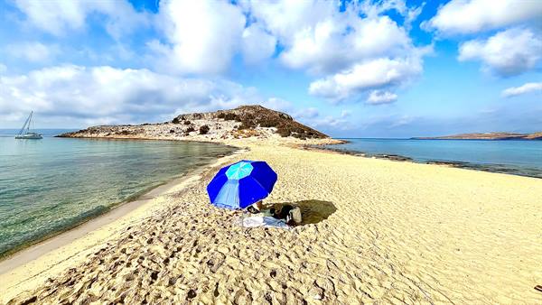 Just us, a blue umbrella and the sea cradling the beach.