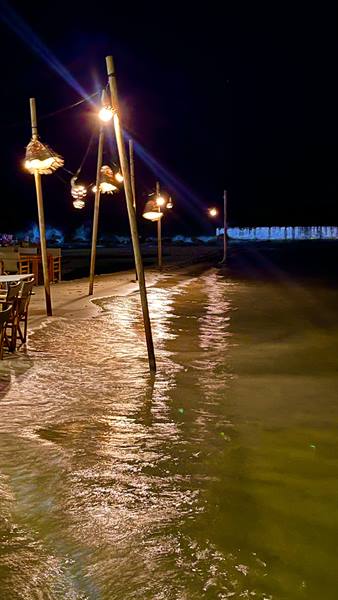 Lamps on the sea, dancing lights: a magical evening on the beach.