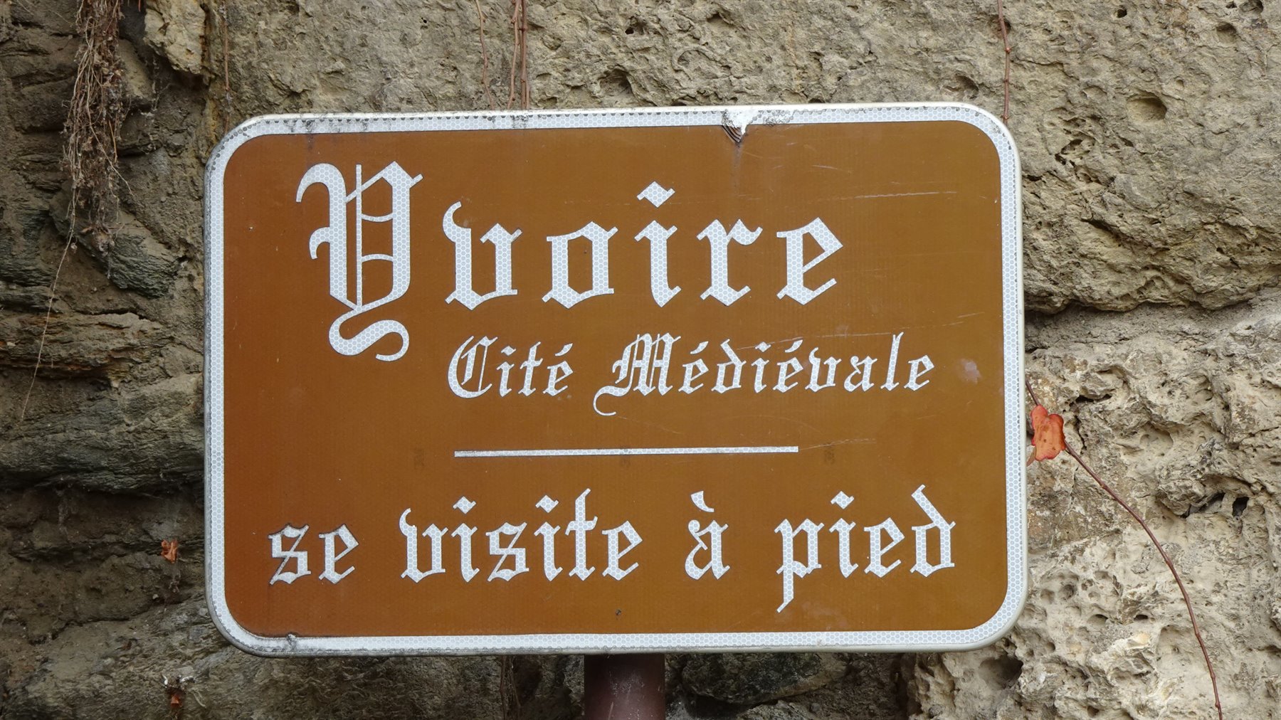 Cartello marrone di Yvoire, Cité Médiévale, su muro di pietra