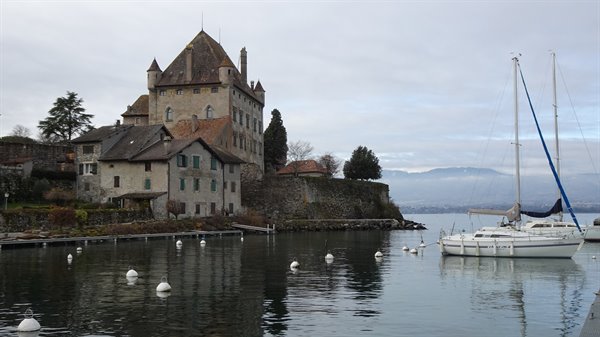 Yvoire medieval castle by the lake with sailboats moored