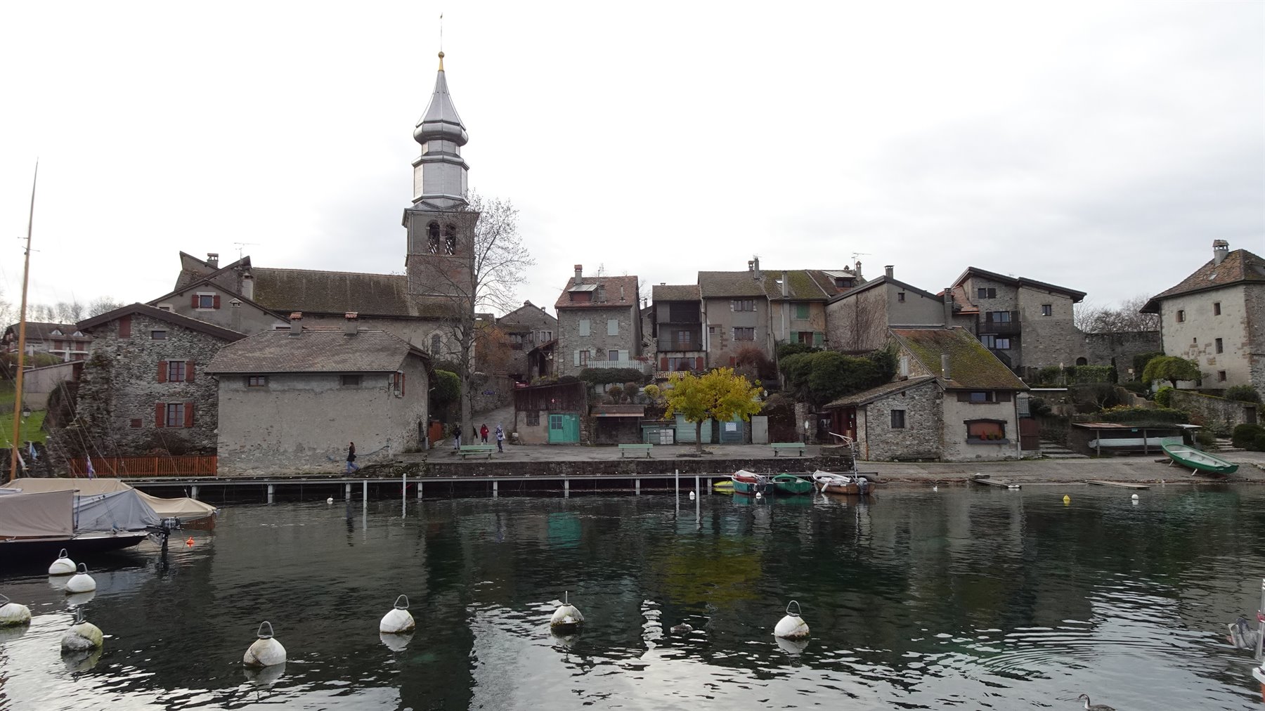 Yvoire: borgo in pietra con campanile a cipolla affacciato sul lago, barche ormeggiate