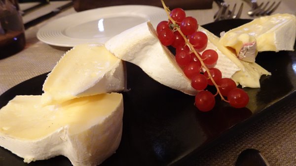 Table in Annecy: soft white cheese and red currants on black plate