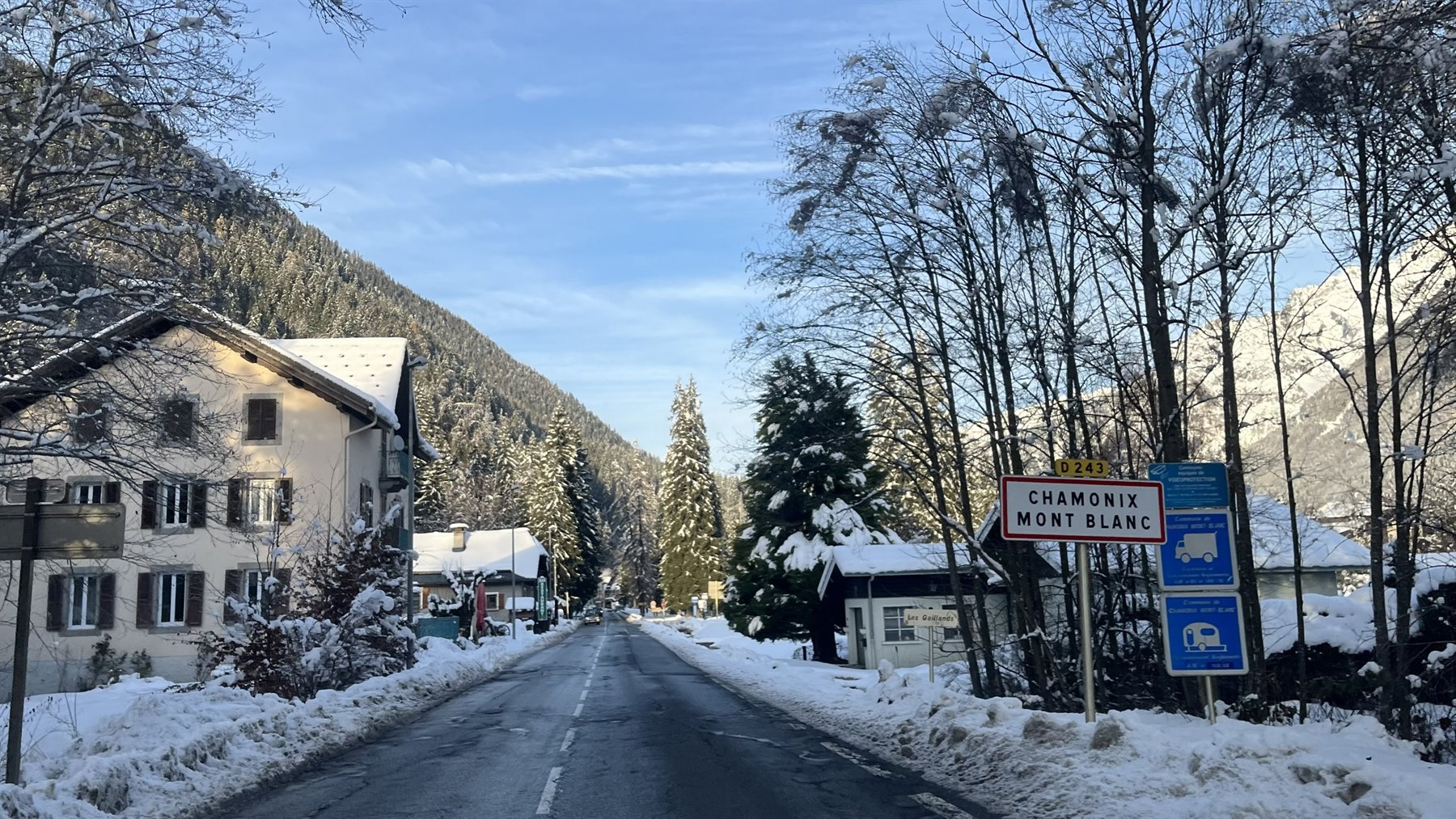 Strada innevata a Chamonix, case e abeti coperti di neve
