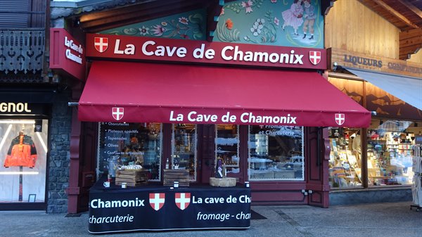 Red La Cave de Chamonix sign over a wooden specialty food shop