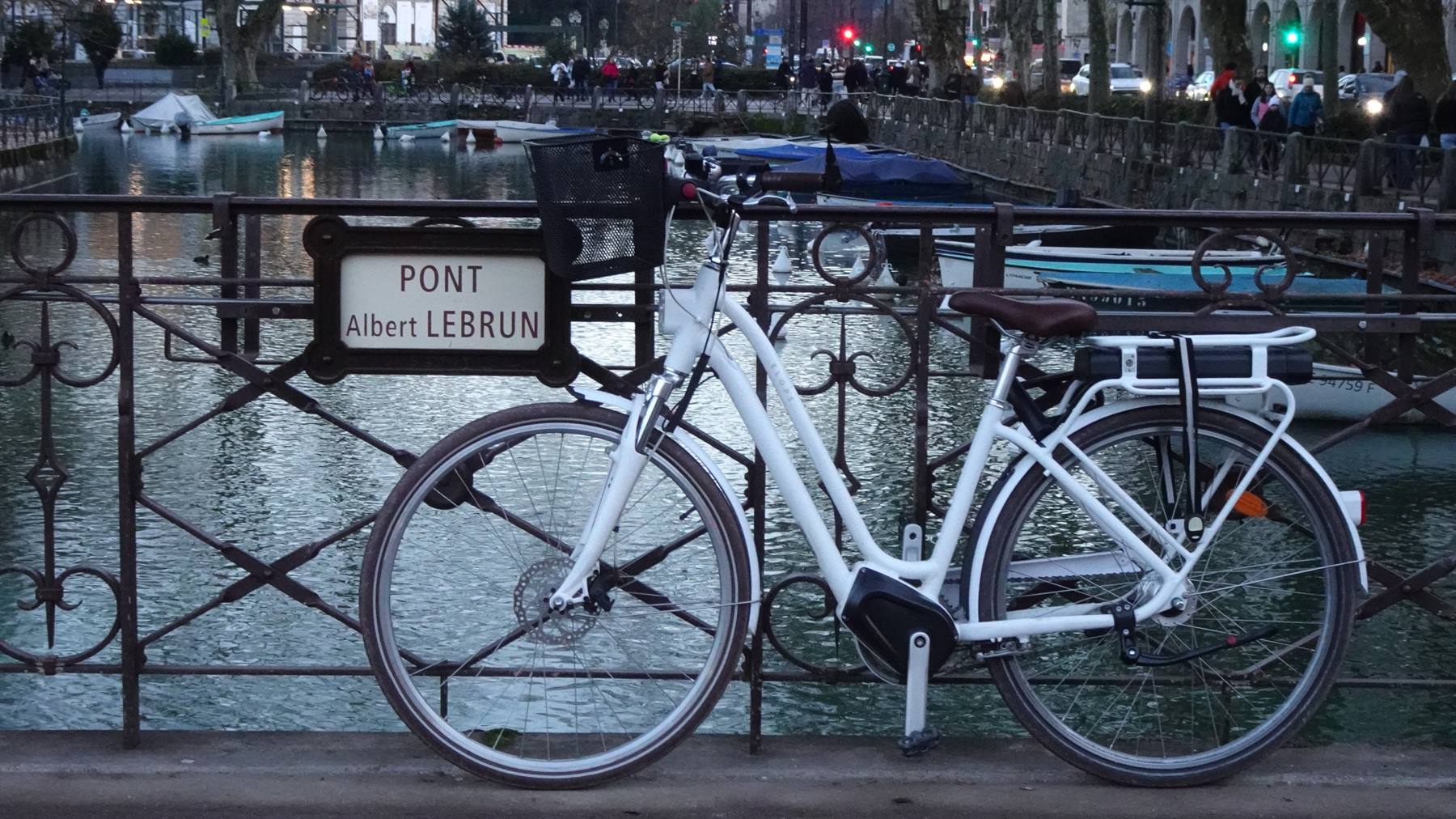 Bici bianca sul Pont Albert Lebrun, canale con barche ad Annecy