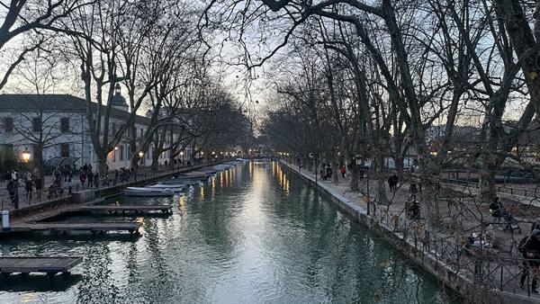 Moored boats along tree-lined canal at dusk, Annecy