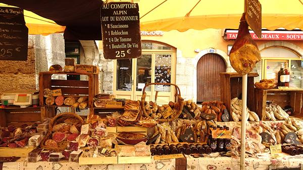 Cheese and cured meats stall under yellow umbrella, Au Comptoir Alpin sign