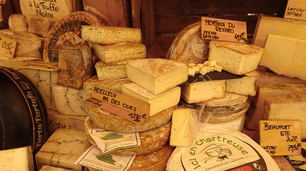 Cheese stall at market, wheels of tomme and beaufort with handwritten signs