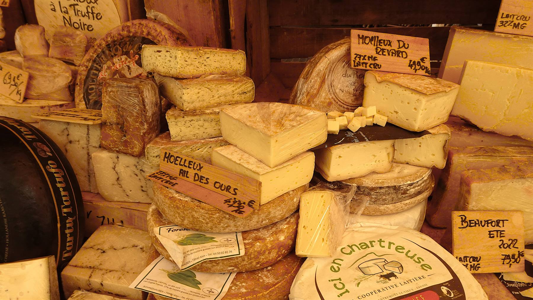 Banchetto di formaggi al mercato, tomme e beaufort con scritte a mano