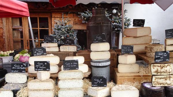 Mountain cheese stall at a market in Yvoire, chalkboard price signs