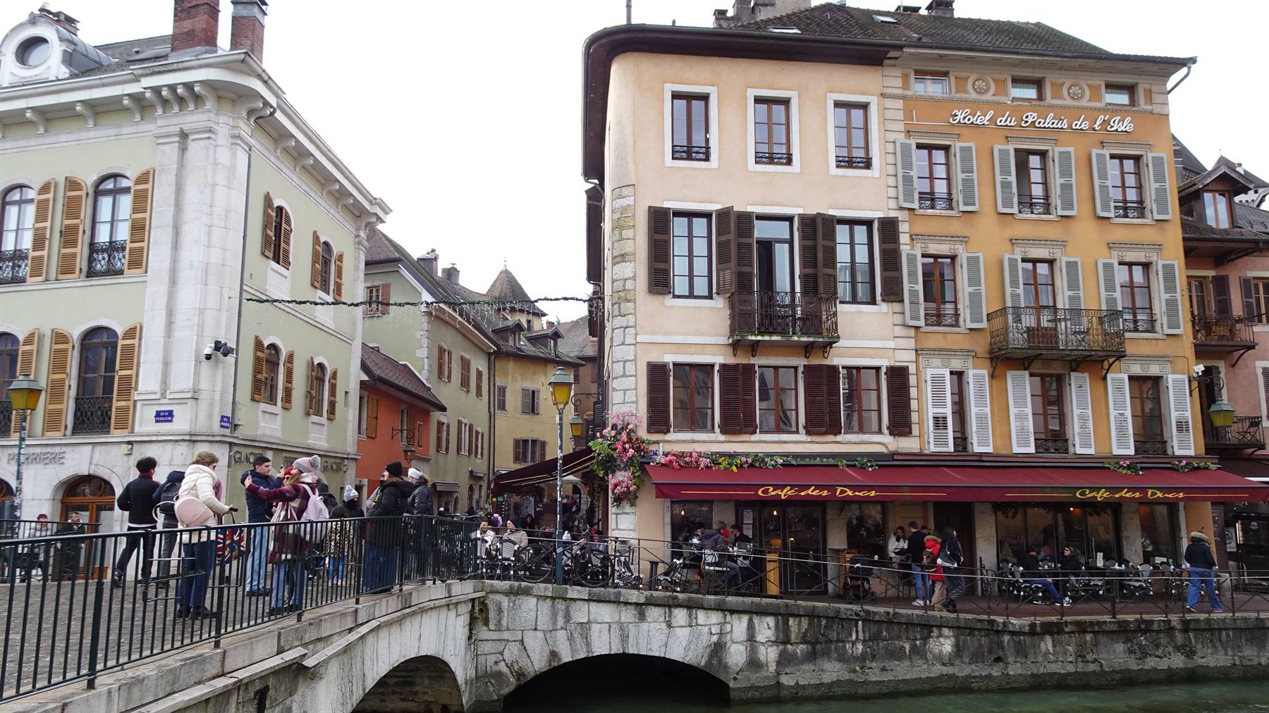 Turisti sul ponte sul canale davanti all'Hôtel de France ad Annecy