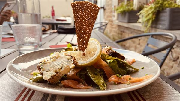 Salad plate with smoked salmon, crisp bread, on an outdoor terrace