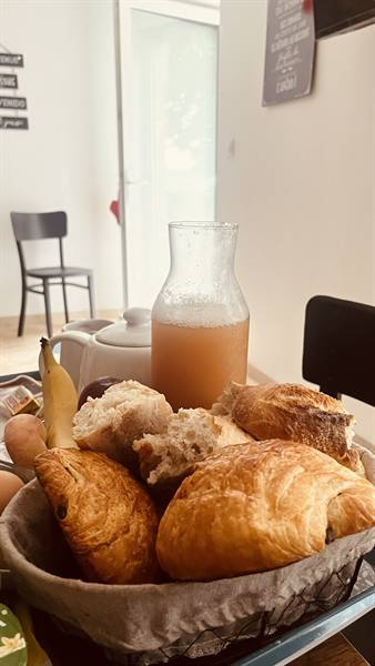 Basket of croissants and bread, pitcher of cider, Normandy breakfast