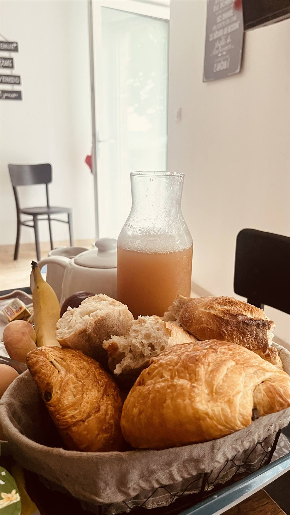 Cesto con croissant e pane, brocca di sidro, colazione in Normandia