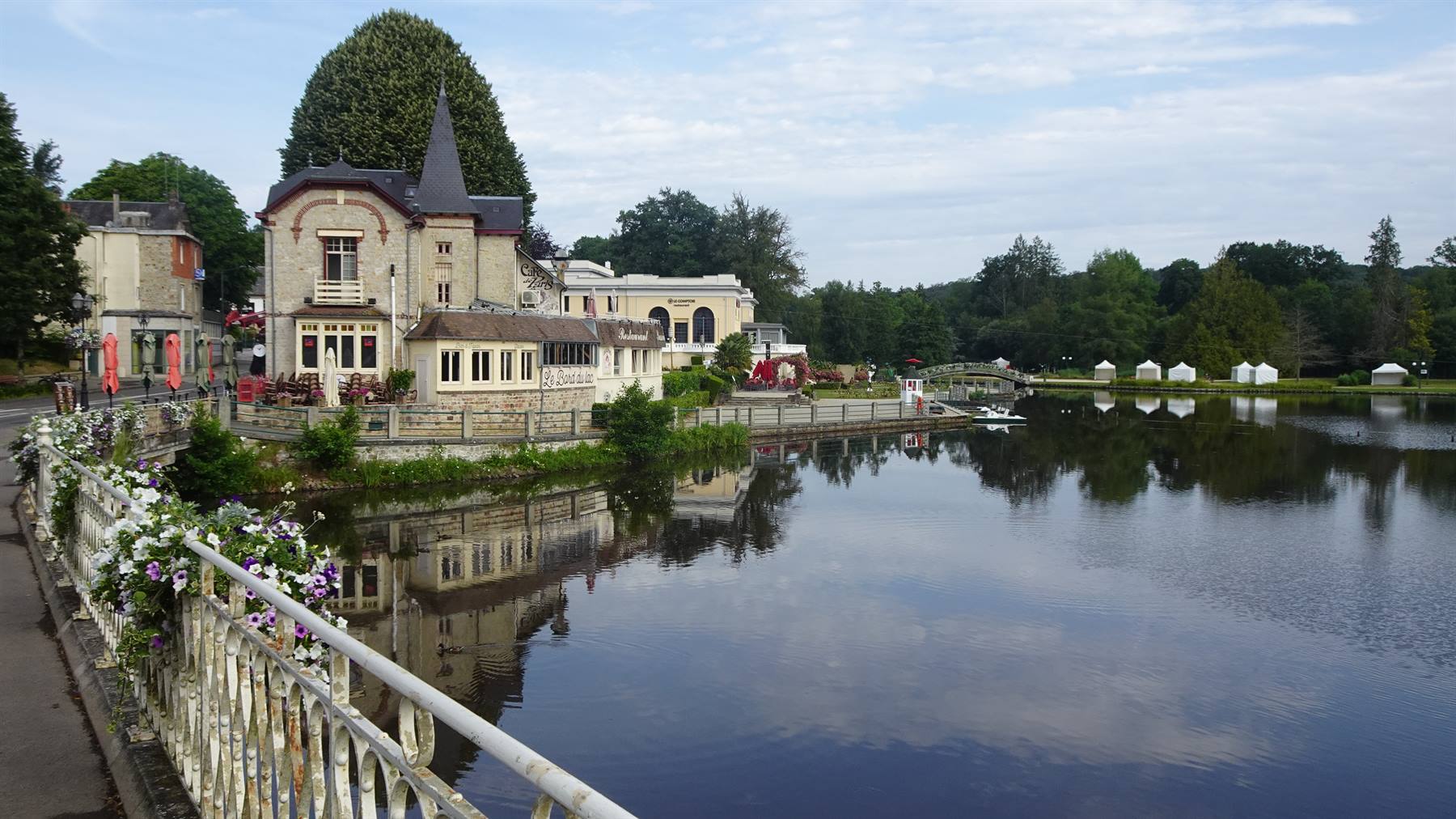 Villa con torretta sul lago di Bagnoles de l'Orne, riflessi e ringhiera fiorita