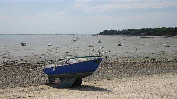 Blue boat stranded on sand, low-tide boats in Cancale bay