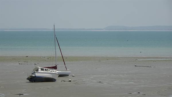 Boats stranded on sand at low tide, in Cancale