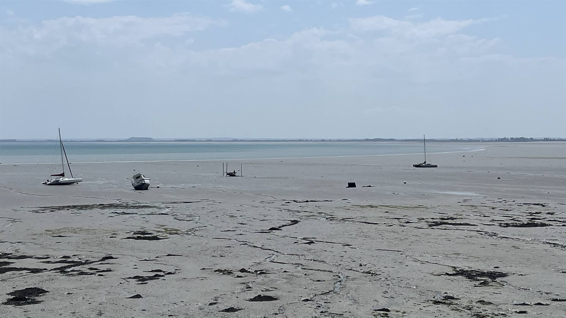 Barche incagliate sulla sabbia in bassa marea a Gouville sur Mer