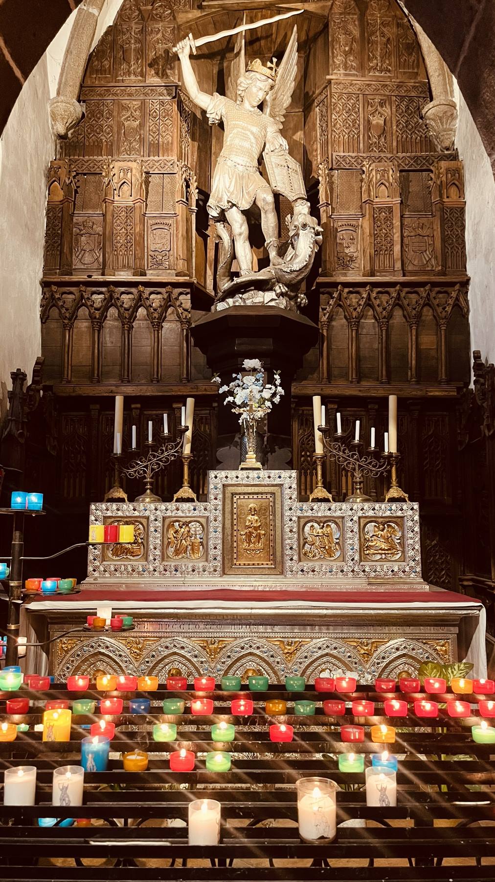Statua di San Michele Arcangelo sull'altare, candele accese, Mont Saint Michel