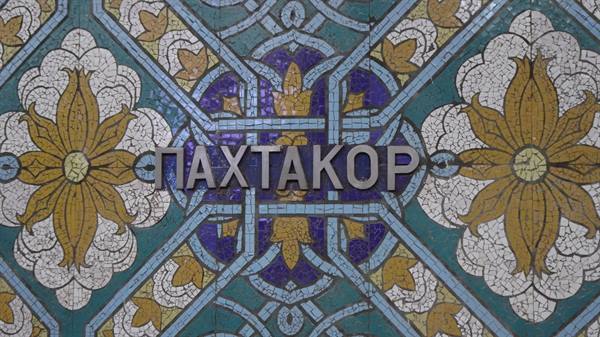 Scritta Pakhtakor sulla maiolica a mosaico blu e oro della metropolitana di Tashkent