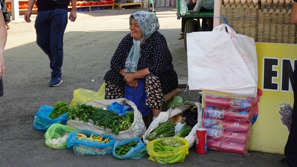 Donna con foulard vende verdure nei sacchetti al mercato di Tashkent