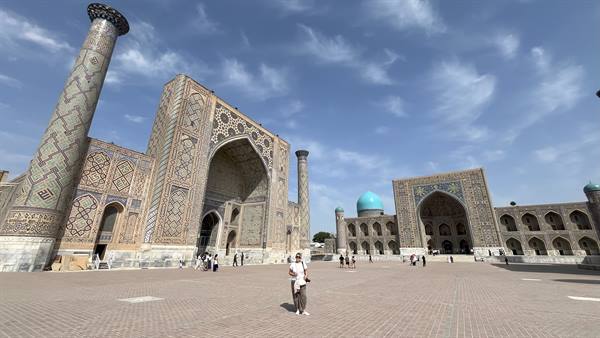 Viaggiatrice sul grande piazzale del Registan a Samarcanda