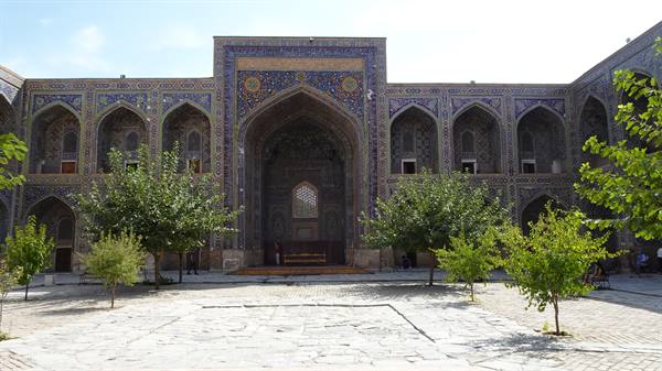 Il cortile della madrasa Sherdor a Samarcanda, piastrelle azzurre e alberi verdi