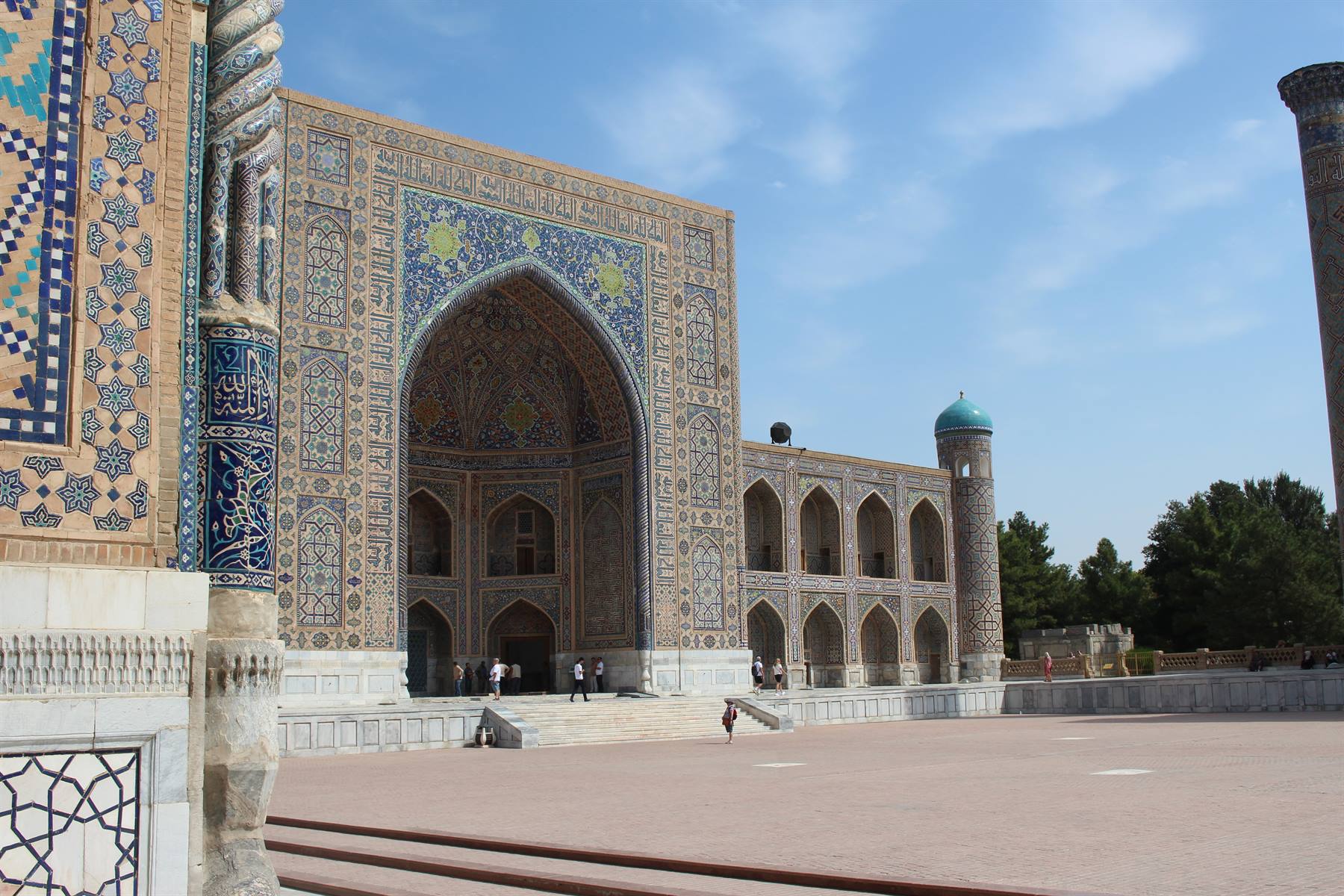 Il grande portale maiolicato del Registan di Samarcanda, turisti passeggiano