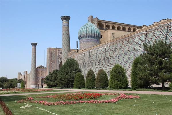 Il Registan di Samarcanda: cupole turchesi, minareti e aiuole fiorite sotto il sole